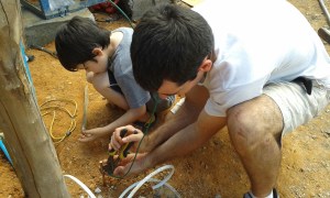 My son and I connecting to the grounding rod. Safety first.
